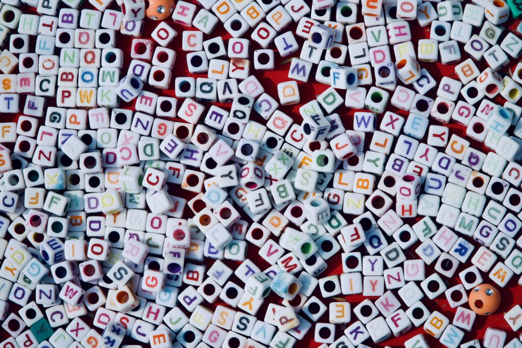 A vibrant assortment of alphabet beads spread across a red surface, showcasing creativity and education.